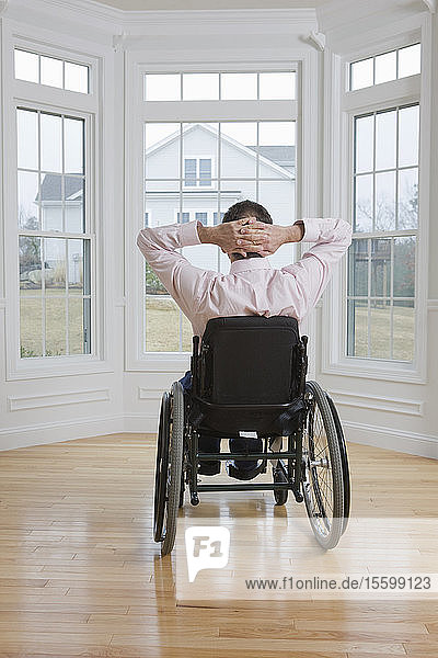 Man sitting in a wheelchair with his hands behind his head