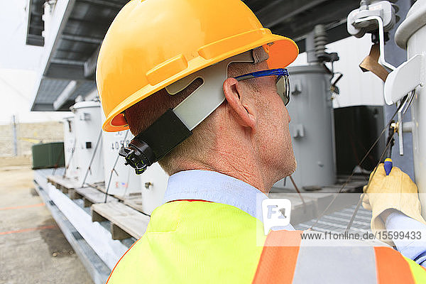 Engineer at electric power plant at storage area for transformers