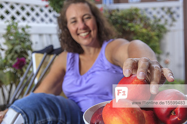 Frau mit Spina Bifida genießt Obst im Sommer