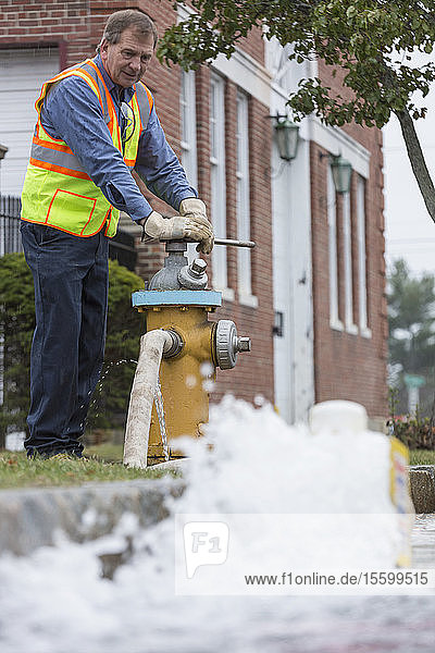 Ein Techniker der Wasserbehörde öffnet einen Hydranten  um die Wasserleitungen zu spülen
