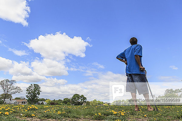Man with Traumatic Brain Injury standing in a field of flowers