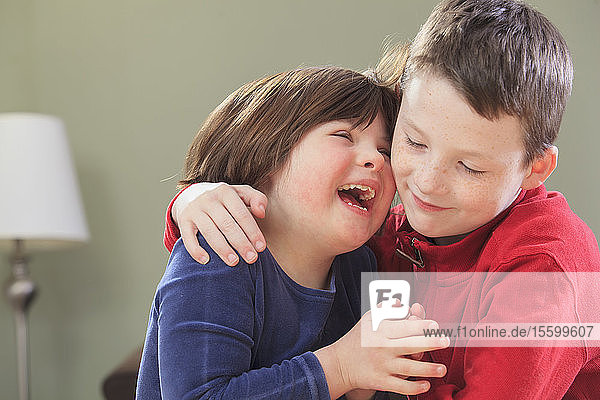 Little girl with Down Syndrome laughing with her brother