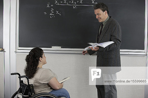 Professor und Student mit Spina Bifida in einem Klassenzimmer