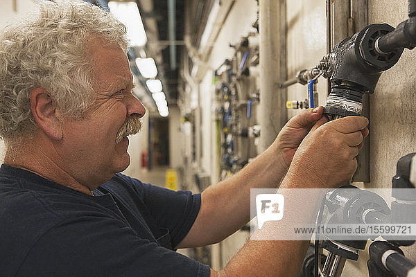 Ingenieur  der eine umgebaute elektrochemische O2-Sensorsonde an einer Rohrleitung in einer Wasseraufbereitungsanlage in Betrieb nimmt