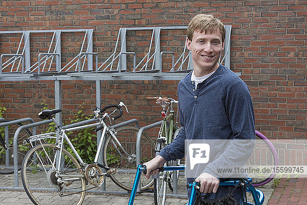 Mann mit zerebraler Lähmung neben einem Fahrradständer