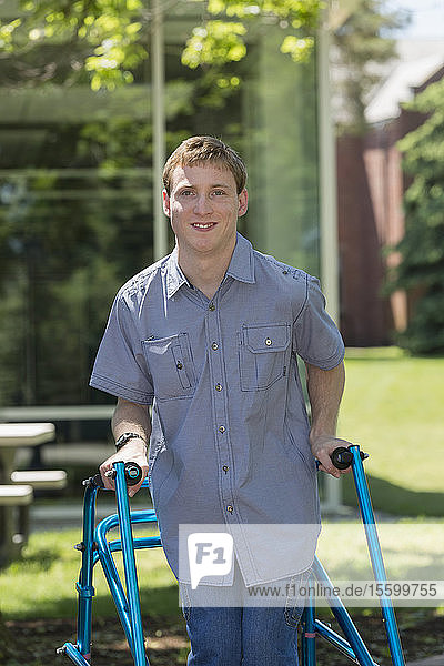 Junger Mann mit Cerebralparese benutzt seinen Rollator  um zur Arbeit zu gehen
