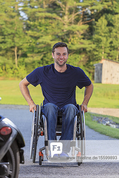 Mann mit Querschnittslähmung im Rollstuhl auf dem Weg zur Arbeit