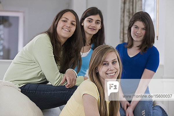Two Hispanic teenage girls smiling with their friends
