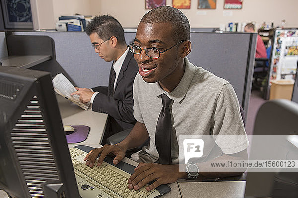 Two men with Autism working on computer in an office