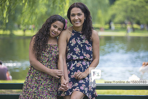 Porträt einer glücklichen hispanischen Frau mit ihrer jugendlichen Tochter mit Zahnspange in einem Park