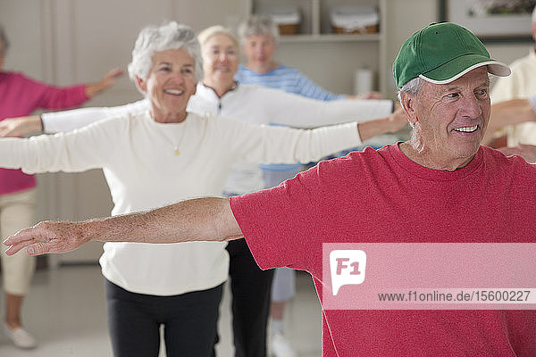 Seniors doing arm strengthening exercises in a health club