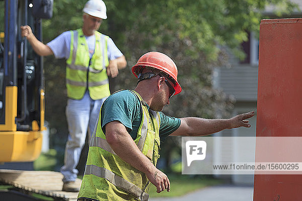 Construction worker directing placement of shoring