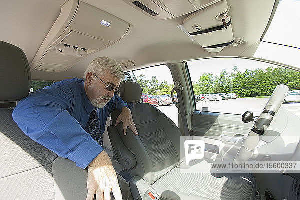 Ein Mann mit Muskeldystrophie und Diabetes steigt in den Vordersitz eines barrierefreien Lieferwagens