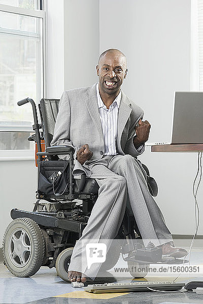 Geschäftsmann mit Cerebralparese arbeitet mit seinem Fuß an einem Computer