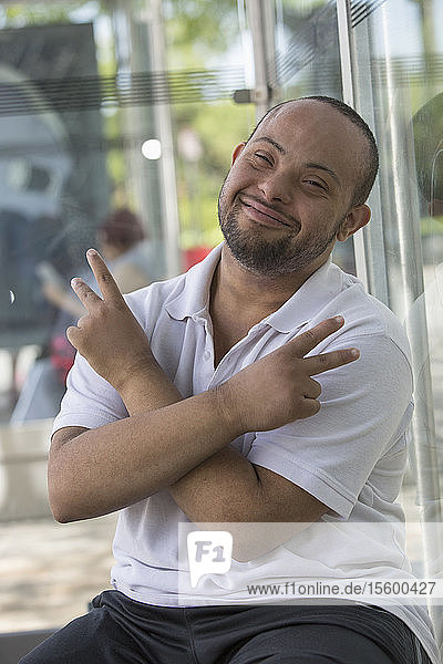 Man with Down Syndrome sitting at a bus stop