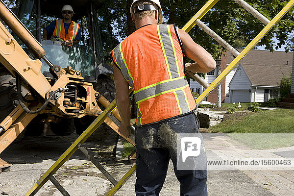 Two construction workers with heavy equipment