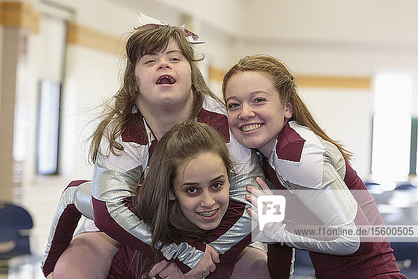 Porträt von drei Cheerleadern  die sich amüsieren  einer davon mit Down-Syndrom