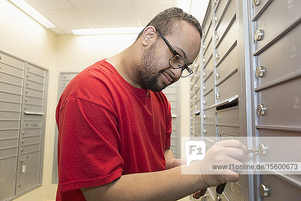 Afroamerikanischer Mann mit Down-Syndrom bei der Kontrolle seines Briefkastens