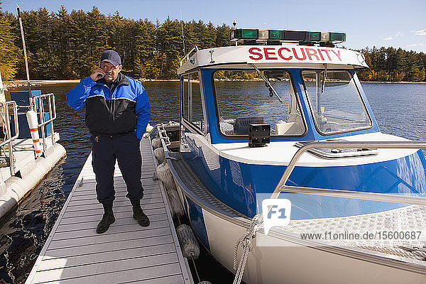 Security guard talking on a mobile phone at a dock