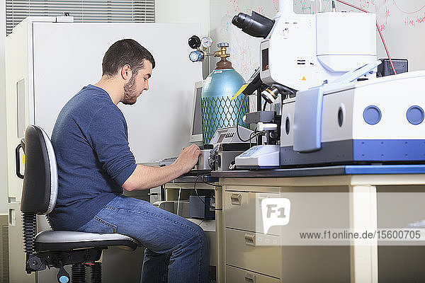 Ingenieurstudent beim Lesen des Bildschirms eines chemischen Analysegeräts in einem Labor