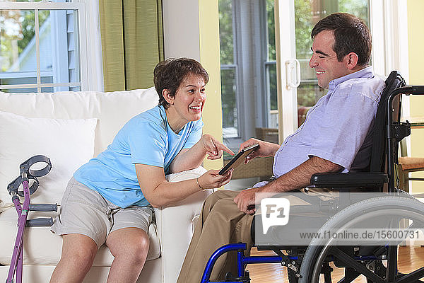Couple with Cerebral Palsy looking at a digital tablet