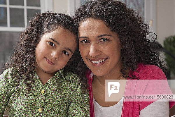 Hispanische Frau lächelt mit ihrer Tochter