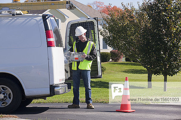 Home cable installer pulling equipment out of his truck