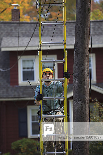 Elektriker klettert auf Leiter an Strommast