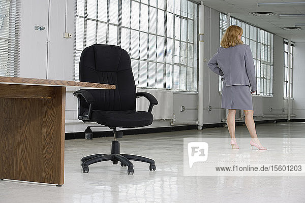 Rückansicht einer Frau  die in einem Büro steht.