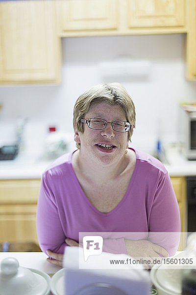 Frau mit Autismus lächelt am Esstisch