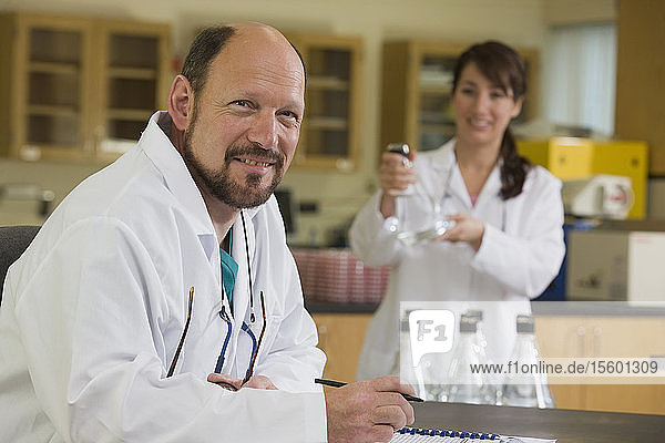 Wissenschaftlerin mit Laborantin im Hintergrund