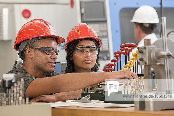 Ingenieurstudenten bei der Auswahl von Bohrern für eine CNC-Maschine