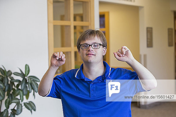 Junger Mann mit Down-Syndrom genießt seine Arbeit in einer Klinik
