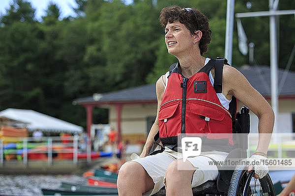 Frau mit einer Rückenmarksverletzung im Rollstuhl auf einem Bootssteg