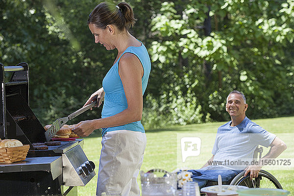 Mann mit Rückenmarksverletzung im Rollstuhl genießt Picknick mit seiner Frau