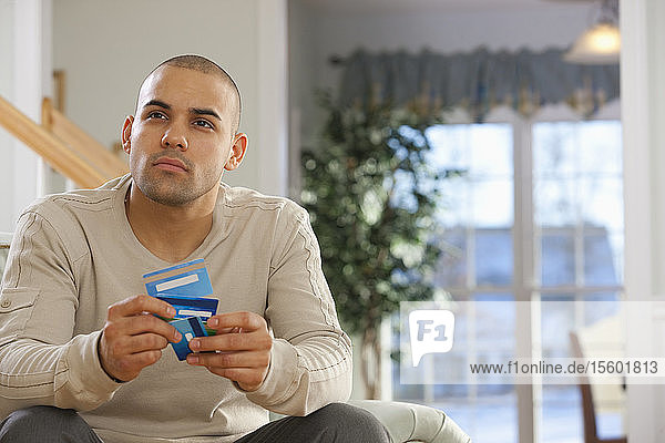 Hispanischer Mann wählt Kreditkarten
