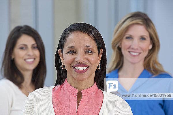 Portrait of a Hispanic woman smiling with her friends in the background