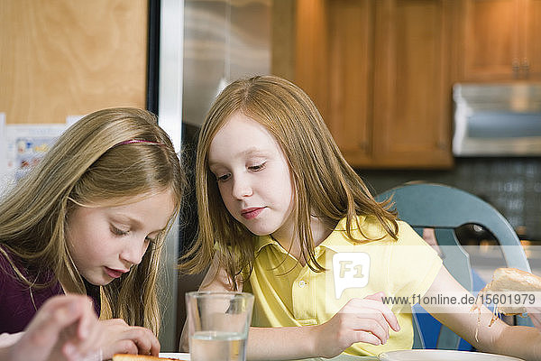 View of two girls eating pizza.
