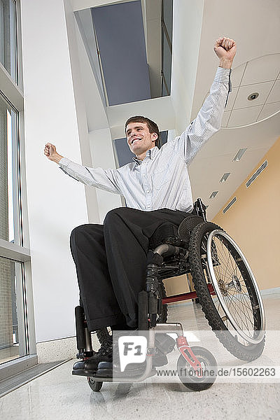 Geschäftsmann mit Rückenmarksverletzung im Rollstuhl  der sich freut