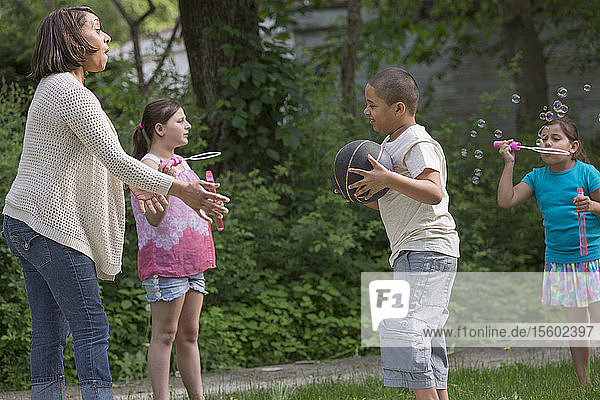 Hispanic boy with Autism playing outside with his family