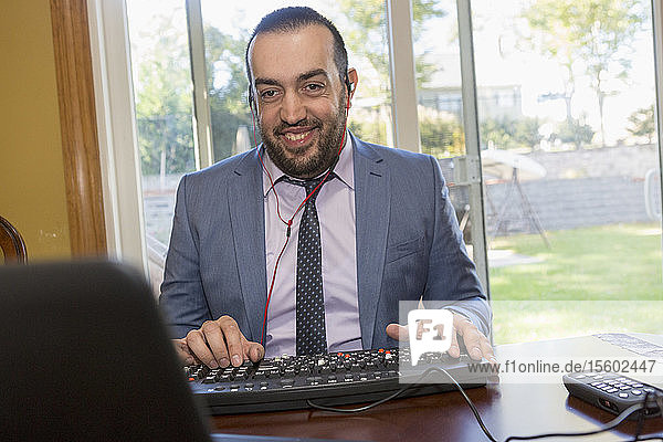 Geschäftsmann mit Sehbehinderung hört auf seinen Computer