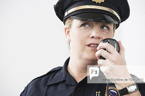 Eine Polizeibeamtin spricht in ein Handmikrofon.