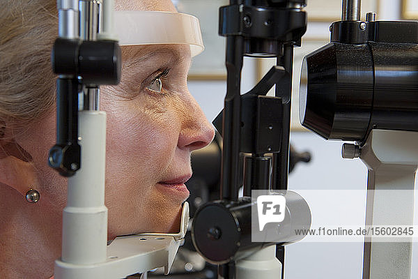 Woman getting eye exam with a slit lamp