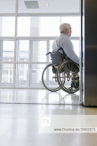 Universitätsprofessor mit Muskeldystrophie sitzt in einem Rollstuhl