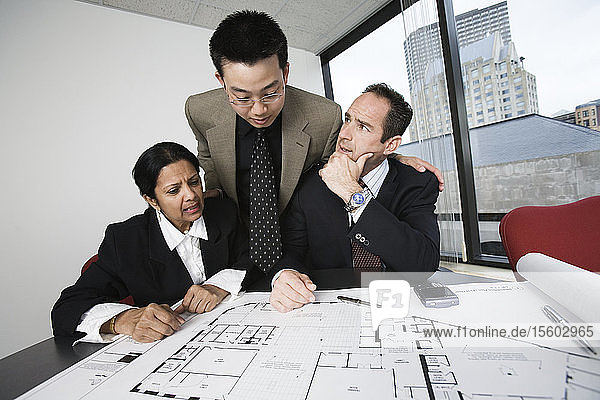 Blick auf einen Architekten  der mit einer Geschäftsfrau in einem Büro plant.