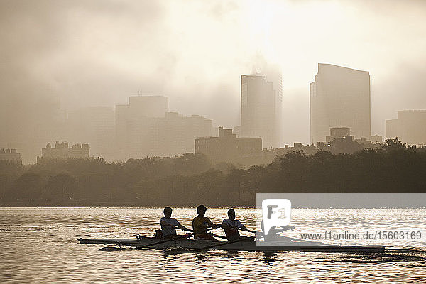 People rowing a boat in a river with city in the background Charles River Back Bay Boston Massachusetts USA