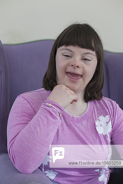 Mädchen mit Down-Syndrom entspannt sich in ihrem Wohnzimmer