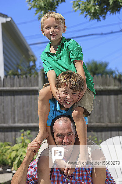 Porträt einer glücklichen Familie mit Hörbehinderung beim Spielen im Hinterhof