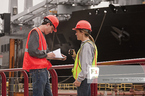 Ingenieure eines Hafenterminals bei der Überprüfung von Dokumenten in einem Handelsdock