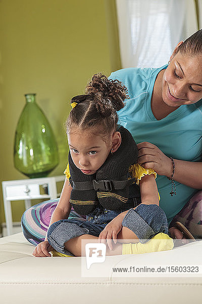 Mutter legt ihrer kleinen Tochter mit Cerebralparese eine Zahnspange an